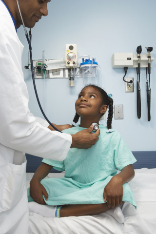 Black girl child smiling at black doctor