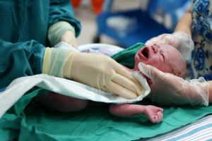 newborn being held by doctors hands