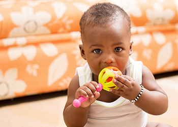 baby chewing on a toy